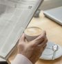 close-up of the hands of an unrecognizable older man holding a newspaper and a cup of coffee